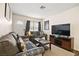 Bright living room with gray sofas, a coffee table, and a large TV at 3982 Voxna St, Las Vegas, NV 89119