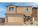 Two-story house with tan exterior, two-car garage, and landscaped front yard at 4219 Gold Desert St, North Las Vegas, NV 89032