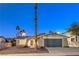 Single-story home with gray garage door and palm trees at 5117 Dancer Way, Las Vegas, NV 89107