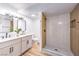 Modern bathroom featuring double vanity, framed mirrors, and a tiled shower with glass door at 701 N Yale St, Las Vegas, NV 89107