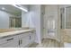 Bathroom with white vanity, large mirror and tiled shower at 7024 Bluebird Wing St, North Las Vegas, NV 89084