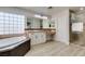 Elegant bathroom with soaking tub, walk-in shower, and modern vanity at 7024 Bluebird Wing St, North Las Vegas, NV 89084