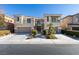 Two-story home with attached two-car garage, landscaping, and a gated entry at 7024 Bluebird Wing St, North Las Vegas, NV 89084