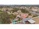 Expansive aerial view featuring a sparkling pool, lush landscaping, custom garage and Las Vegas skyline at 7450 Via Olivero Ave, Las Vegas, NV 89117