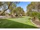 Expansive backyard featuring putting green, gazebo, mature trees, and lush landscaping at 7450 Via Olivero Ave, Las Vegas, NV 89117