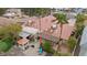 Backyard oasis with a covered patio, lush green landscaping, a putting green, and a spiral staircase at 7450 Via Olivero Ave, Las Vegas, NV 89117