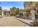 Backyard featuring an outdoor kitchen, a bar, stone pathway, and lush landscaping at 7450 Via Olivero Ave, Las Vegas, NV 89117