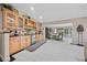 Bar area featuring wood cabinets, glass storage, tile backsplash, and an open floor plan at 7450 Via Olivero Ave, Las Vegas, NV 89117