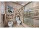 Bathroom with a toilet, and an enclosed shower with neutral-toned tile and a backyard view at 7450 Via Olivero Ave, Las Vegas, NV 89117