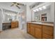 Bathroom with a sit-down vanity, wood cabinets, and a connecting room with a bathtub and toilet at 7450 Via Olivero Ave, Las Vegas, NV 89117