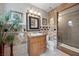 Full bathroom with custom tile, framed mirror, single sink vanity, toilet and glass enclosed shower at 7450 Via Olivero Ave, Las Vegas, NV 89117