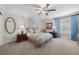 Comfortable bedroom featuring carpet floors, ceiling fan, and blue curtains for a relaxing ambiance at 7450 Via Olivero Ave, Las Vegas, NV 89117