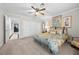 Bedroom with light colored walls, light colored carpet and a large bed with decorative pillows at 7450 Via Olivero Ave, Las Vegas, NV 89117