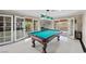 Bright billiard room has a pool table and access to the outdoor patio at 7450 Via Olivero Ave, Las Vegas, NV 89117