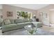 Bright living room featuring a comfortable sectional sofa and large window view at 7450 Via Olivero Ave, Las Vegas, NV 89117