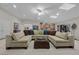 Large living room featuring a large sectional sofa, decorative pillows, and a ceiling fan at 7450 Via Olivero Ave, Las Vegas, NV 89117