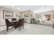 Open concept living room with tile floors, a dining table set and a large window at 7450 Via Olivero Ave, Las Vegas, NV 89117