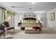 Spacious main bedroom with carpet flooring, accent chairs, a large bed, and natural light at 7450 Via Olivero Ave, Las Vegas, NV 89117