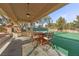 Outdoor bar under pergola with seating overlooking tennis court in private backyard at 7450 Via Olivero Ave, Las Vegas, NV 89117