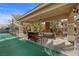 Covered outdoor bar and seating area overlooking a tennis court at 7450 Via Olivero Ave, Las Vegas, NV 89117