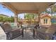 Covered outdoor living area with slate flooring, comfortable seating, and view of backyard and pool at 7450 Via Olivero Ave, Las Vegas, NV 89117