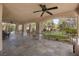 Covered outdoor living area with ceiling fans and stone flooring and comfortable seating with pool view at 7450 Via Olivero Ave, Las Vegas, NV 89117