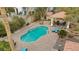 Aerial view of a sparkling swimming pool, surrounded by a brick patio and lush landscaping at 7450 Via Olivero Ave, Las Vegas, NV 89117