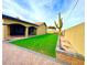 Spacious backyard with artificial turf, covered patio, and a large cactus at 7874 Clearwood Ave, Las Vegas, NV 89123