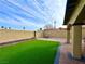 Backyard patio with artificial turf and a seating area at 7874 Clearwood Ave, Las Vegas, NV 89123