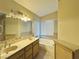 Bathroom with double vanity, bathtub, and window at 7874 Clearwood Ave, Las Vegas, NV 89123