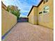 Side yard with brick pavers and a modern black gate at 7874 Clearwood Ave, Las Vegas, NV 89123