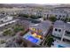 An aerial view of the home showing a pool, solar panels and the surrounding community at 8 Hilltop Crest St, Henderson, NV 89011