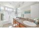 Bright bathroom with double sinks, light wood cabinets, a white bathtub with a white shower curtain at 8 Hilltop Crest St, Henderson, NV 89011