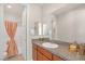 Bathroom featuring a shower and tub combo with a peach colored curtain and wood cabinets with granite counters at 8 Hilltop Crest St, Henderson, NV 89011