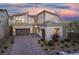 Two-story modern home with gray exterior, solar panels, and a paver driveway at 8 Hilltop Crest St, Henderson, NV 89011