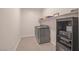 Bright laundry room featuring a gray washer and dryer and convenient built-in shelving for storage at 8 Hilltop Crest St, Henderson, NV 89011