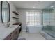 Modern bathroom with soaking tub, glass shower, and block window at 8120 Castle Pines Ave, Las Vegas, NV 89113