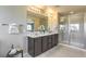 Double vanity bathroom with a large mirror, shower, and modern finishes at 8406 Sycamore Creek St, Las Vegas, NV 89113