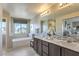 Bathroom with soaking tub, double vanity, and a large mirror at 8406 Sycamore Creek St, Las Vegas, NV 89113