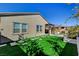 Backyard with artificial turf, stone pathways, and a relaxing seating area at 9016 Skye Canyon Ranch St, Las Vegas, NV 89166