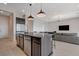 Kitchen island with seating, stainless steel appliances, and dark cabinetry at 9016 Skye Canyon Ranch St, Las Vegas, NV 89166