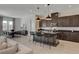 Open concept kitchen with dark cabinets, large island, and modern pendant lights at 9016 Skye Canyon Ranch St, Las Vegas, NV 89166