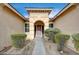 Elegant entryway with arched doorway, stone flooring, and well-placed landscaping at 9092 National Park Dr, Las Vegas, NV 89178