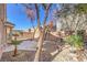 Landscaped backyard with mature trees, gravel, and a patio, creating a peaceful outdoor space at 9328 Freedom Heights Ave, Las Vegas, NV 89149