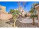 A charming backyard featuring gravel landscaping, mature trees, and a concrete patio area for outdoor living at 9328 Freedom Heights Ave, Las Vegas, NV 89149