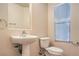 Cozy half-bathroom featuring a pedestal sink and toilet, complete with essential fixtures at 9328 Freedom Heights Ave, Las Vegas, NV 89149