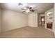 Carpeted bedroom with a ceiling fan and an arched doorway to the ensuite bathroom at 9328 Freedom Heights Ave, Las Vegas, NV 89149