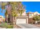 Charming two-story home featuring a well-manicured lawn, mature trees, and an attached two-car garage at 9328 Freedom Heights Ave, Las Vegas, NV 89149