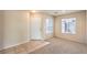 Bright living room featuring tile and carpet flooring, complemented by natural light from two windows at 9328 Freedom Heights Ave, Las Vegas, NV 89149