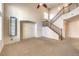 Spacious living room area with neutral carpet and a staircase at 9328 Freedom Heights Ave, Las Vegas, NV 89149